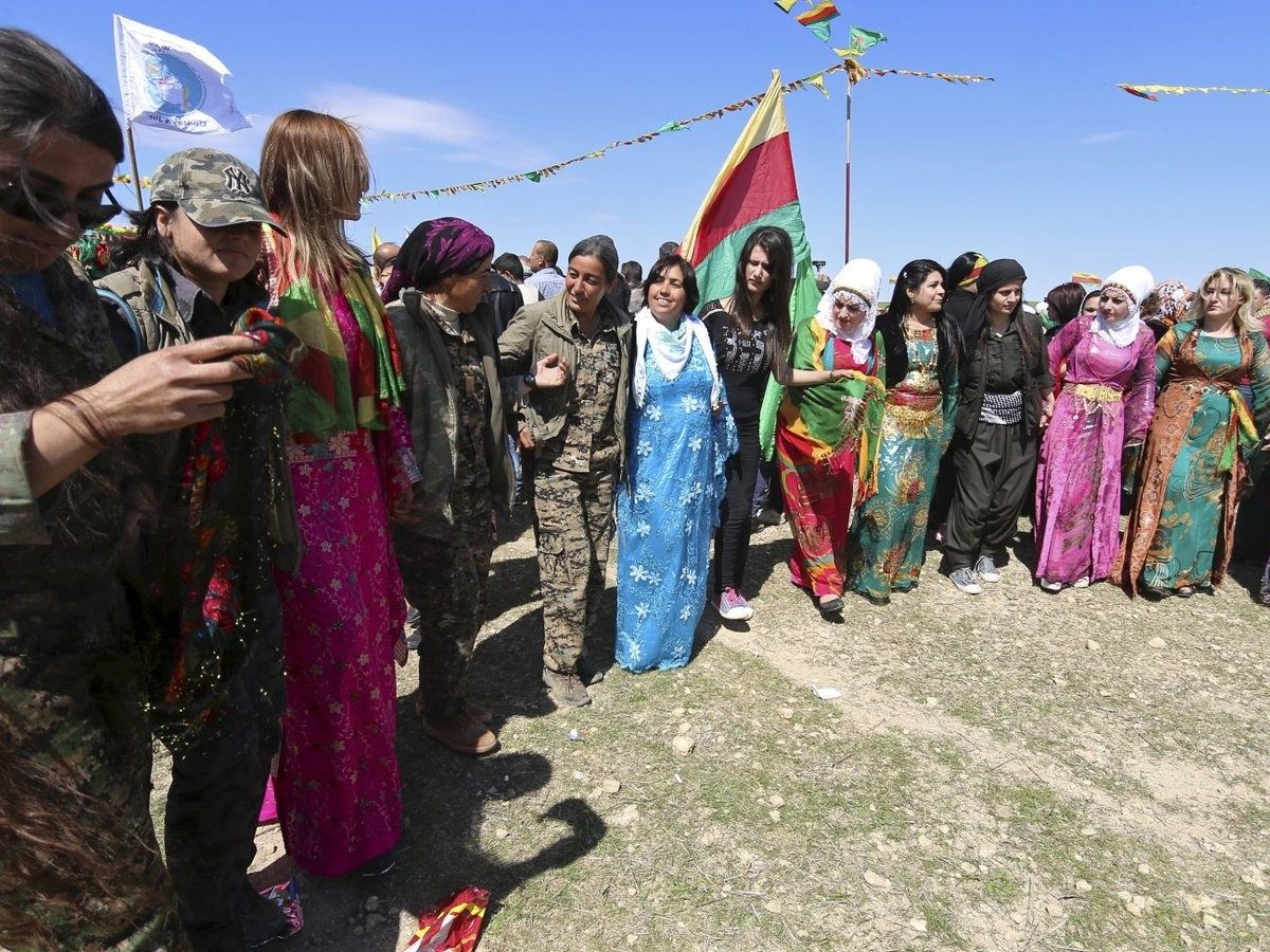 مقاتلات قوات حماية المرأة (YPJ) يحتفلن بعيد نوروز مع نساء مدنيات في القامشلي ، سوريا عام 2016.