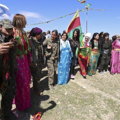 مقاتلات قوات حماية المرأة (YPJ) يحتفلن بعيد نوروز مع نساء مدنيات في القامشلي ، سوريا عام 2016.